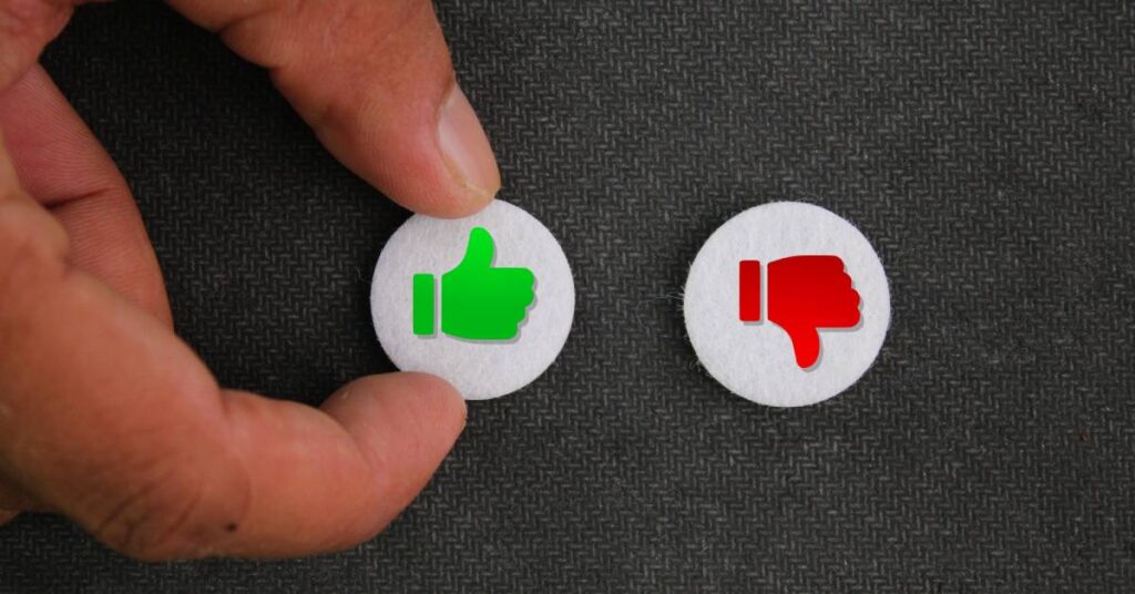 A close-up of a hand touching a thumbs-up button. There is a thumbs-down button next to it.